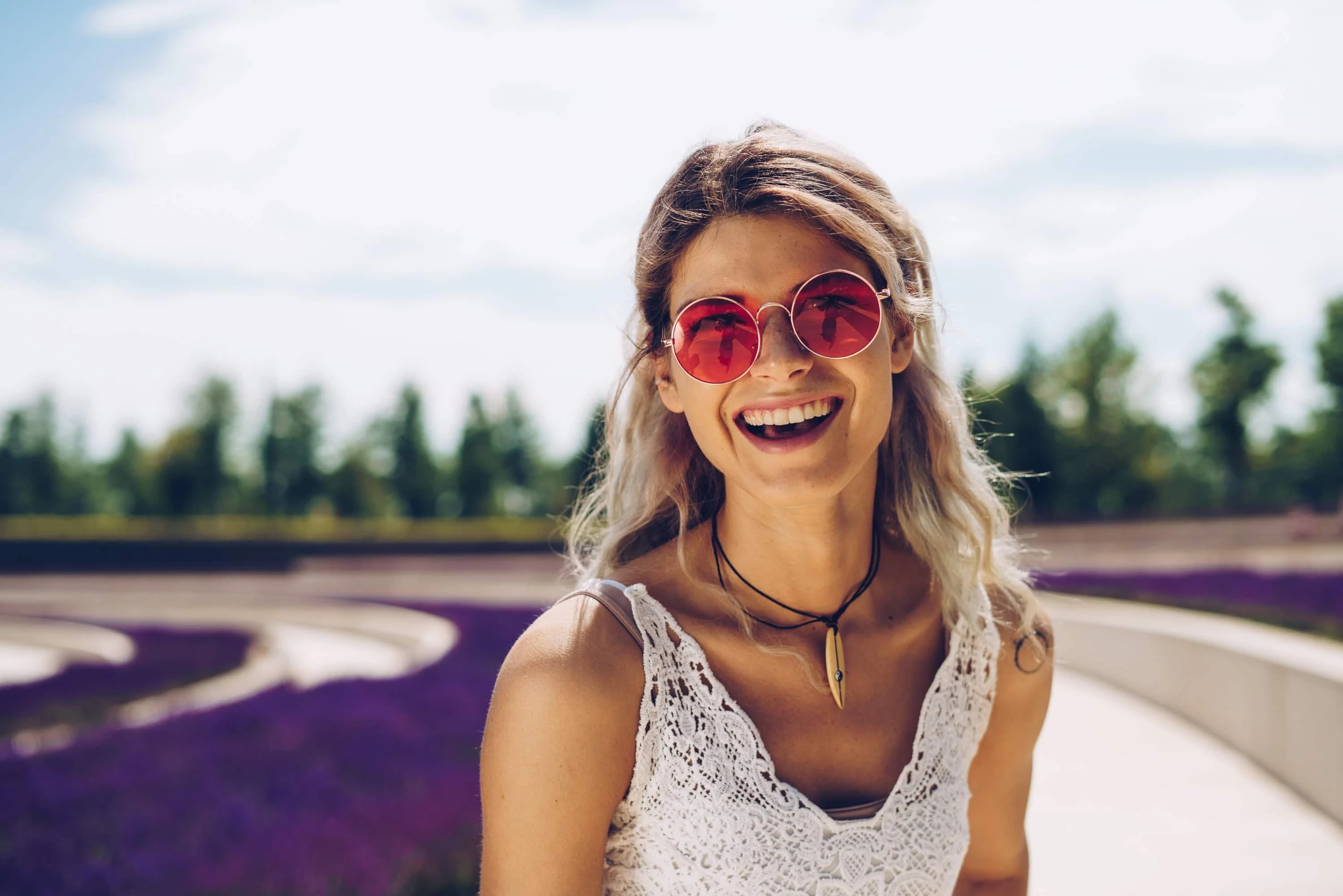Smiling lady in a lavender field with sunglasses on